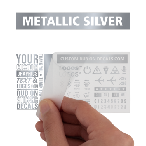 A person is holding a metallic silver rub on transfer.